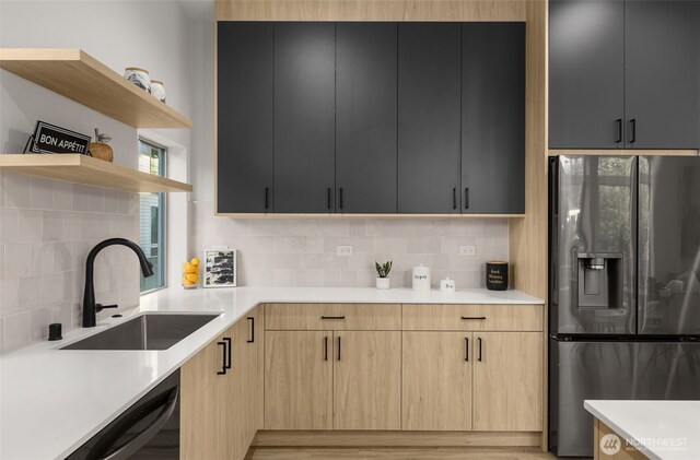 kitchen with fridge with ice dispenser, a sink, open shelves, light countertops, and decorative backsplash