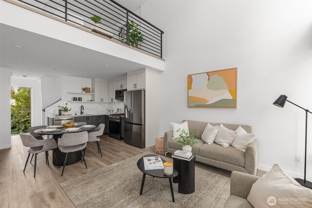 living room featuring light wood finished floors and a towering ceiling