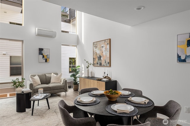 dining area featuring a wall unit AC and a high ceiling