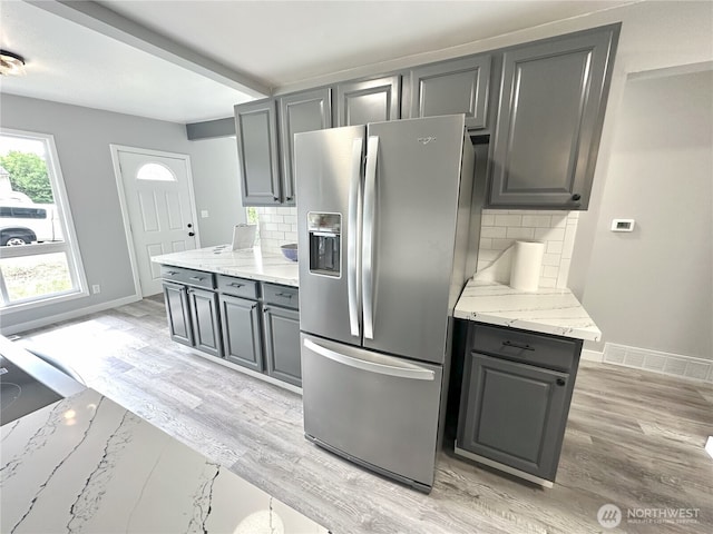 16738 2nd Ave NE, Shoreline, WA 98155 - kitchen featuring stainless steel fridge, gray cabinetry, decorative backsplash, light stone counters, and light wood-type flooring