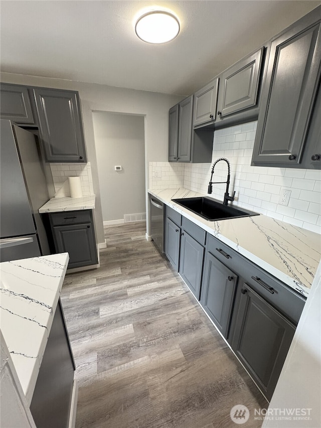 16738 2nd Ave NE, Shoreline, WA 98155 - kitchen with appliances with stainless steel finishes, light wood-type flooring, tasteful backsplash, and gray cabinetry