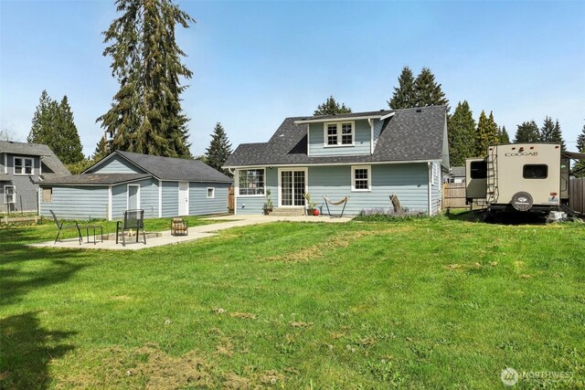 rear view of property featuring a yard, a patio, an outdoor structure, and entry steps