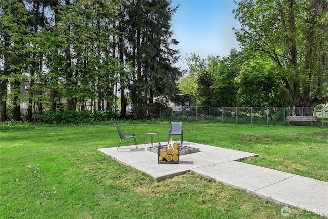 view of property's community with fence, a yard, and a patio area