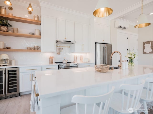 204 Market St Unit A, Pacific Beach, WA 98571 - kitchen with ornamental molding, beverage cooler, white cabinetry, a wall unit AC, and appliances with stainless steel finishes