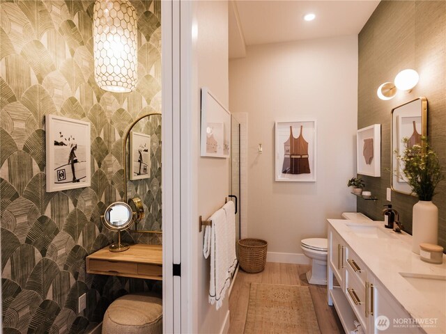 204 Market St Unit A, Pacific Beach, WA 98571 - bathroom featuring a sink, double vanity, toilet, baseboards, and wood finished floors