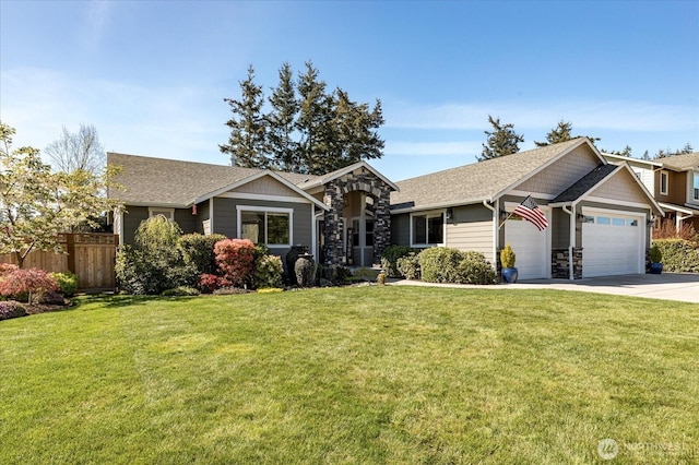 view of front of home with an attached garage, fence, a front lawn, and a shingled roof