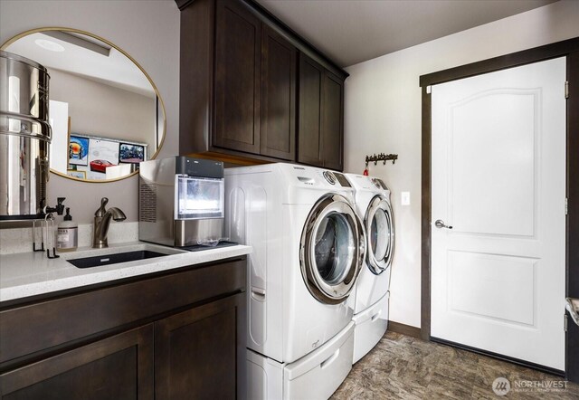 clothes washing area with baseboards, cabinet space, washer and clothes dryer, and a sink