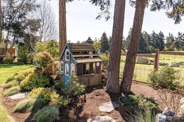 view of side of property featuring a lawn and fence