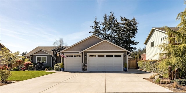 craftsman house with concrete driveway, a front lawn, fence, and an attached garage