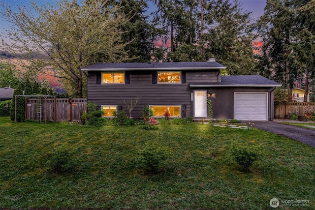 10927 102nd Ave SW, Lakewood, WA 98498 - split level home featuring a yard, an attached garage, a chimney, and fence