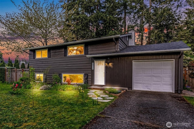 10927 102nd Ave SW, Lakewood, WA 98498 - split level home featuring an attached garage, a lawn, a chimney, and fence