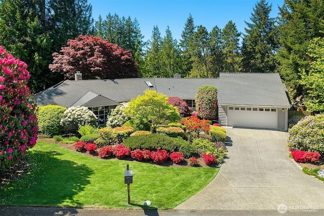 view of front of house with a garage, a front lawn, and driveway