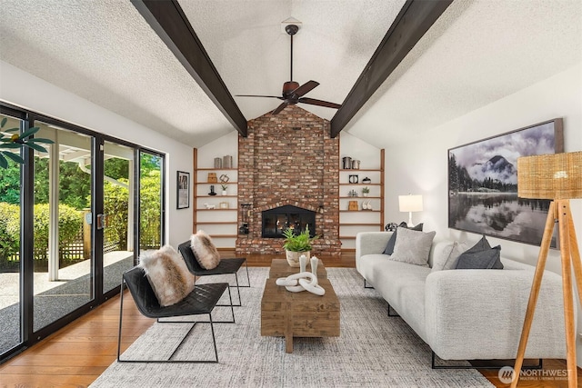 living room with ceiling fan, lofted ceiling with beams, a textured ceiling, built in features, and wood finished floors