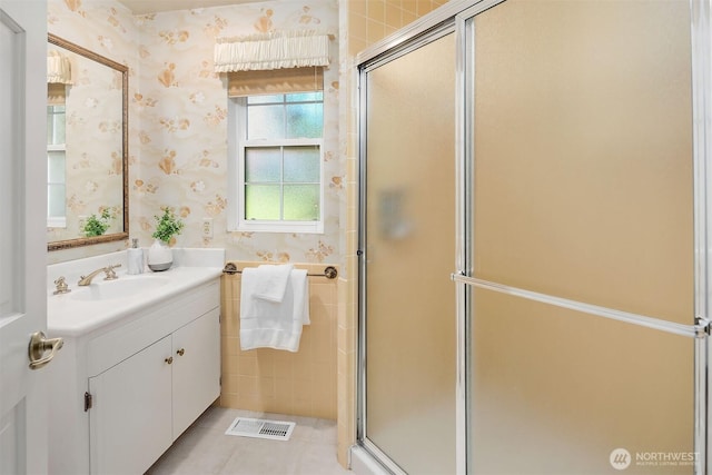 full bath featuring tile patterned flooring, vanity, wallpapered walls, visible vents, and a stall shower