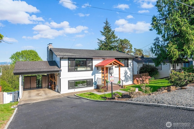 view of front of home featuring stucco siding, aphalt driveway, a chimney, and an attached carport