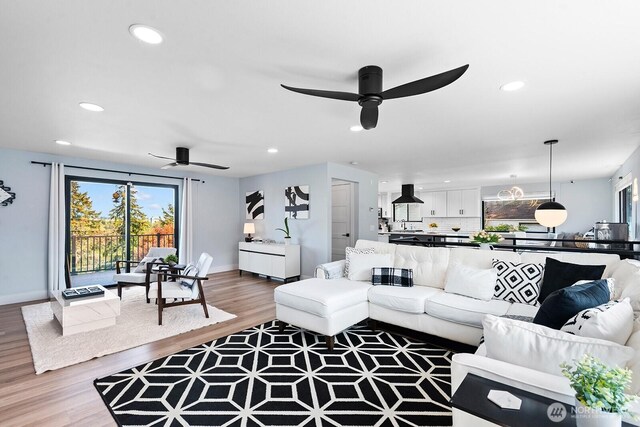 living area featuring recessed lighting, plenty of natural light, wood finished floors, and ceiling fan