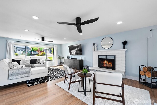 living room with recessed lighting, wood finished floors, a brick fireplace, and a ceiling fan
