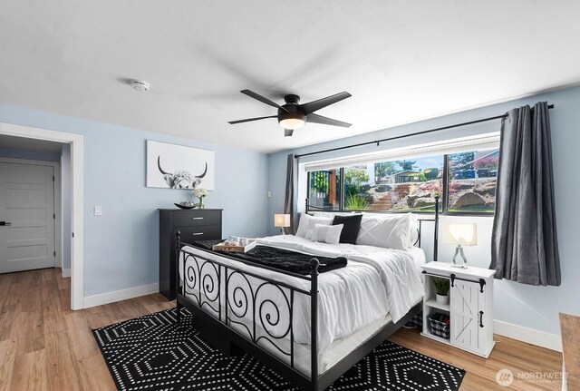 bedroom with baseboards, a ceiling fan, and light wood finished floors