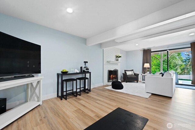 living area with wood finished floors, a fireplace, baseboards, beam ceiling, and recessed lighting