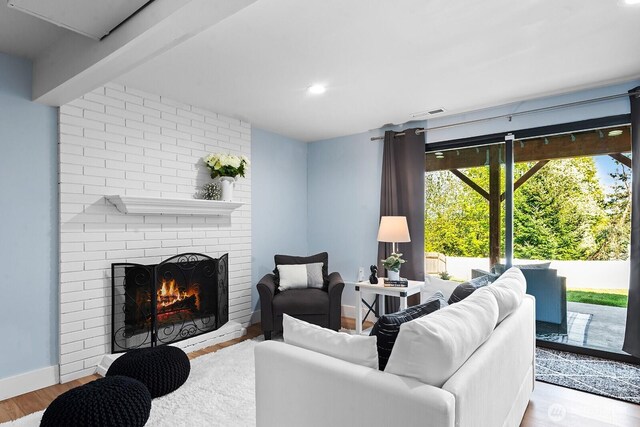 living room with recessed lighting, wood finished floors, visible vents, baseboards, and a brick fireplace