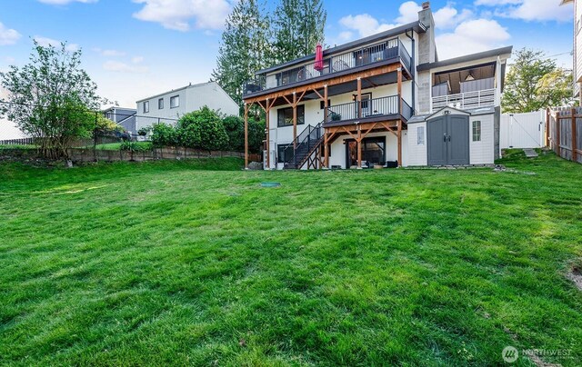 back of property with a fenced backyard, a wooden deck, stairway, an outdoor structure, and a shed