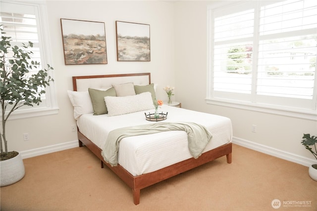 bedroom featuring baseboards and light carpet
