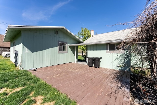 rear view of house featuring a chimney and a deck