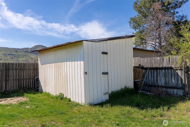 view of shed with a fenced backyard and a mountain view