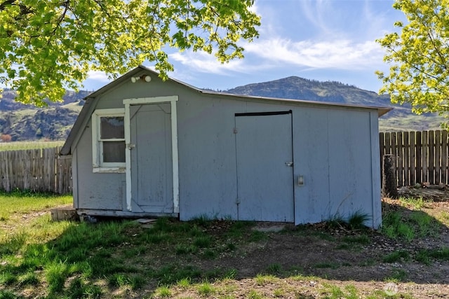 view of shed featuring fence and a mountain view