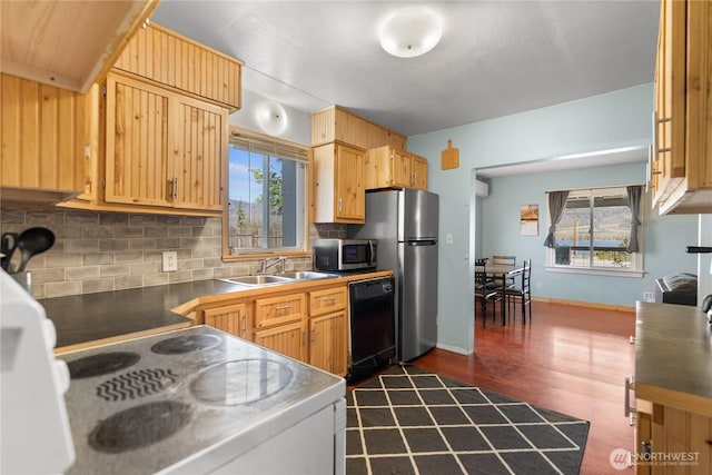 kitchen featuring appliances with stainless steel finishes, dark wood-style floors, decorative backsplash, and a sink
