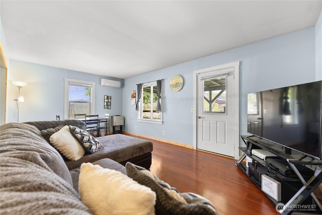 living room featuring wood finished floors and an AC wall unit