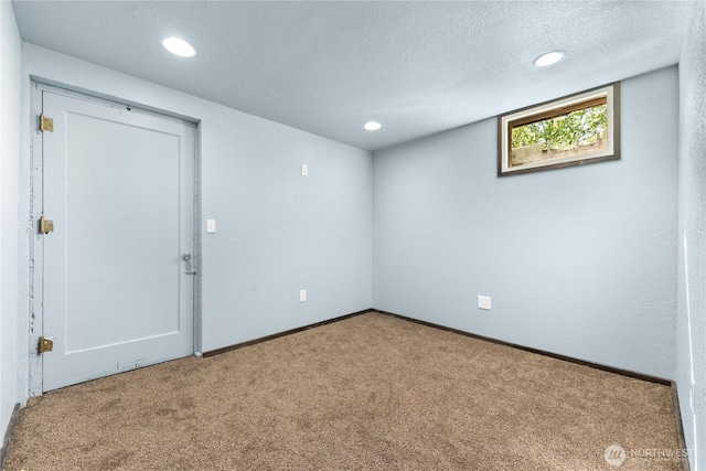 carpeted spare room featuring baseboards, a textured ceiling, and recessed lighting