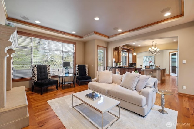 8131 116th Ave NE, Kirkland, WA 98033 - living area featuring crown molding, an inviting chandelier, light wood-style flooring, baseboards, and a tray ceiling
