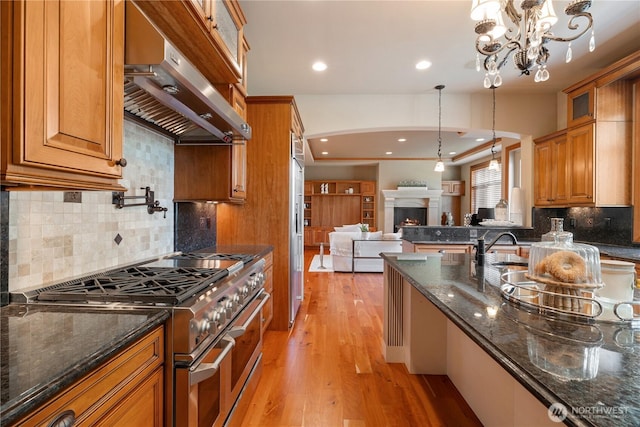 8131 116th Ave NE, Kirkland, WA 98033 - kitchen with high quality appliances, brown cabinets, light wood finished floors, open floor plan, and under cabinet range hood