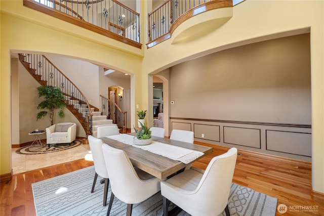 8131 116th Ave NE, Kirkland, WA 98033 - dining room with arched walkways, a towering ceiling, wood finished floors, and stairway