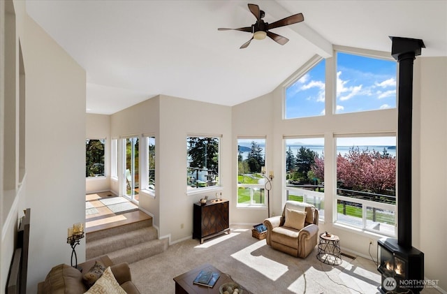 sunroom with a wood stove, a wealth of natural light, and beam ceiling