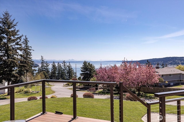 wooden deck featuring a lawn and a water and mountain view