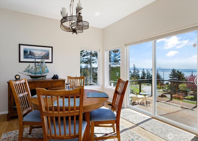dining area featuring wood finished floors, baseboards, and a notable chandelier