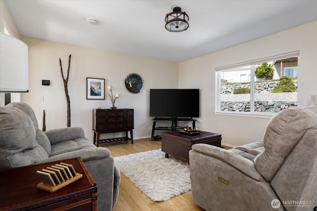 living area with baseboards and light wood-type flooring