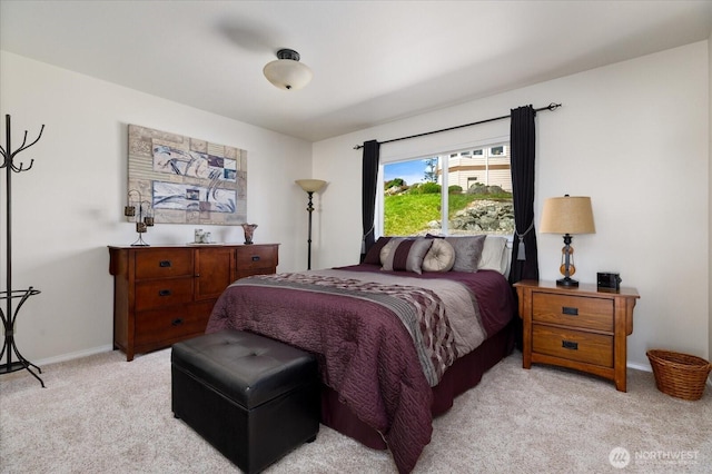 bedroom with light colored carpet and baseboards