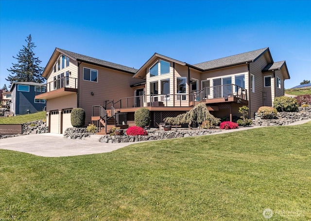 rear view of property featuring stairway, concrete driveway, a lawn, an attached garage, and a wooden deck