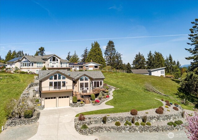 view of front of home with a front yard, an attached garage, stairs, and concrete driveway