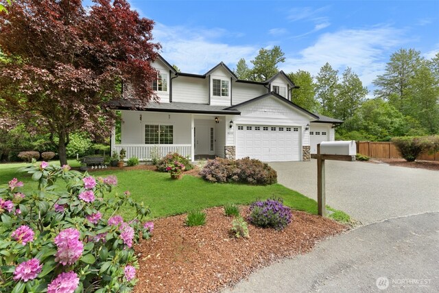 8203 32nd Ave E, Tacoma, WA 98443 - traditional-style home featuring covered porch, an attached garage, stone siding, and concrete driveway