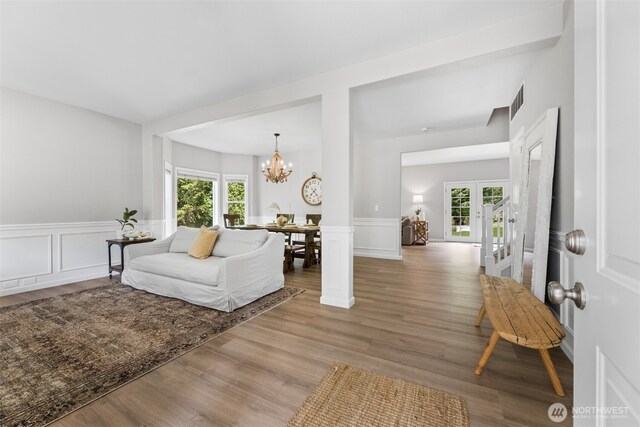 8203 32nd Ave E, Tacoma, WA 98443 - living area with a chandelier, plenty of natural light, wood finished floors, wainscoting, and a decorative wall