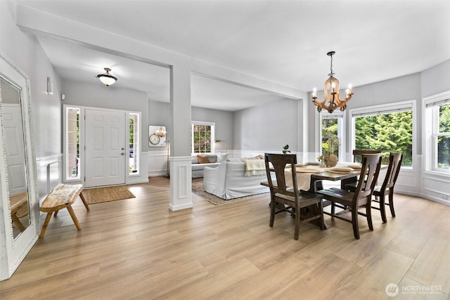 8203 32nd Ave E, Tacoma, WA 98443 - dining area featuring a chandelier, light wood-style flooring, a decorative wall, and a wainscoted wall