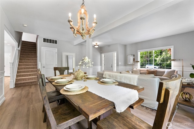 8203 32nd Ave E, Tacoma, WA 98443 - dining room featuring a chandelier, stairway, wood finished floors, wainscoting, and a decorative wall