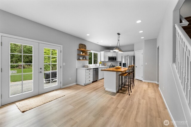 8203 32nd Ave E, Tacoma, WA 98443 - kitchen with butcher block countertops, stainless steel appliances, open shelves, french doors, and white cabinets