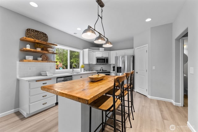 8203 32nd Ave E, Tacoma, WA 98443 - kitchen with appliances with stainless steel finishes, a sink, light wood-style flooring, backsplash, and recessed lighting