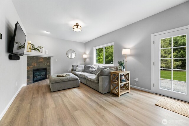 8203 32nd Ave E, Tacoma, WA 98443 - living room with light wood-style flooring, baseboards, and a glass covered fireplace