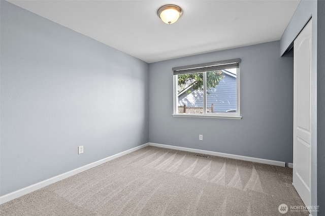 unfurnished bedroom featuring baseboards, visible vents, and carpet